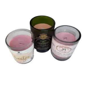 Upcycled scented coloured candles in cut waste wine bottles